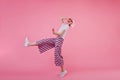 Full-length portrait of young woman in trendy pants dancing in studio with happy smile. Indoor shot Royalty Free Stock Photo