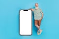 Full length of positive elderly person empty space telephone screen on blue color background