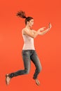 Full length of pretty young woman with mobile phone while jumping Royalty Free Stock Photo