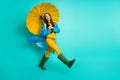 Full length profile photo of attractive lady good mood rainy weather walk hood head puddles hold big yellow umbrella Royalty Free Stock Photo