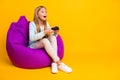 Full length profile photo of beautiful little lady good mood playing video games joystick sitting cozy soft violet bean Royalty Free Stock Photo