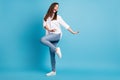 Full length profile photo of crazy lady dancing party wear white shirt jeans sneakers isolated blue color background