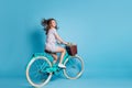 Full length profile photo of girl ride bike pot flowers wear dotted short dress sneakers isolated blue color background Royalty Free Stock Photo