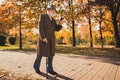 Full length profile photo of retired grey hair grandpa man walk desert park stick read email telephone sunny day use Royalty Free Stock Photo