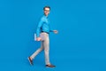 Full length profile side photo of young business man happy positive smile go walk hold laptop isolated over blue color Royalty Free Stock Photo