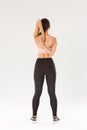 Full length rear view of active and slim brunette asian fitness girl, female athlete warm-up before yoga classes, lock