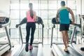 Rear view of a fit woman and her cardio workout partner running Royalty Free Stock Photo