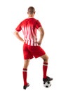 Full length rear view of young male caucasian athlete stepping on soccer ball over white background Royalty Free Stock Photo