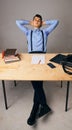 A relaxed confident young businessman sitting with legs on desk at office Royalty Free Stock Photo