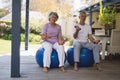 Full length of senior couple exercising at porch Royalty Free Stock Photo