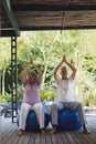 Full length of senior couple meditating sitting together at porch Royalty Free Stock Photo