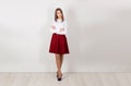 Full length of serious, confident young businesswoman with crossed arms, standing isolated against white wall. One single person. Royalty Free Stock Photo