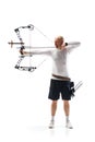 Full-length of serious man, archery sportsman aiming archery bow on target isolated over white studio background Royalty Free Stock Photo