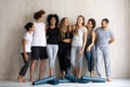 Seven diverse people wearing sportswear wait for yoga class training