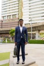 Full length shot of African businessman outdoors in city smiling Royalty Free Stock Photo