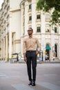 Full length shot of African businessman walking and thinking outdoors in city Royalty Free Stock Photo