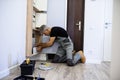 Full length shot of aged electrician, repairman in uniform working, installing an ethernet cable for router in fuse box Royalty Free Stock Photo