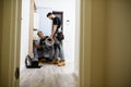 Full length shot of aged electrician, repairman in uniform working, installing ethernet cable or router in fuse box