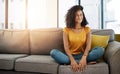 Weekends are made for the sofa. Full length shot of an attractive young woman looking thoughtful while relaxing at home Royalty Free Stock Photo