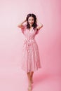 Full-length shot of barefooted girl in long dress laughing to camera. Indoor photo of amazing brune