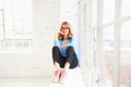 Happy mature woman looking at camera and smiling while relaxing at the window Royalty Free Stock Photo