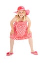 Full length shot of beautiful young blonde girl in big pink floppy hat, a polka dot dress and flip flops. Isolated on white studio Royalty Free Stock Photo