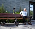 Full length shot of confident, cheerful middle aged businessman smiling while talking on the phone, sitting on the bench Royalty Free Stock Photo