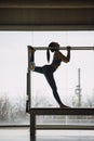 Silhouette of Pilates instructor realizing stretching routine, on a Cadillac Machine