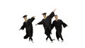 Three male graduates in robes and mortarboards dancing in synch Royalty Free Stock Photo