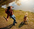 Fetch. Full length shot of a handsome young man playing fetch with his dog by a lake in the park. Royalty Free Stock Photo