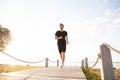 Full length shot of healthy young man running on the promenade. Male runner sprinting outdoors Royalty Free Stock Photo