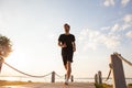 Full length shot of healthy young man running on the promenade. Male runner sprinting outdoors Royalty Free Stock Photo