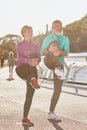 Healthy body. Full length shot of mature man and woman in sportswear smiling, stretching legs while warming up together Royalty Free Stock Photo