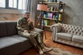 For relieving pain. Full length shot of sad middle aged military man looking away, sitting on the couch during therapy Royalty Free Stock Photo