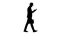 Silhouette Casual man texting on phone and walking. Royalty Free Stock Photo