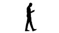 Silhouette Young man walking and using a phone. Royalty Free Stock Photo