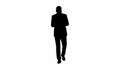 Silhouette Businessman on the phone typing text message walking. Royalty Free Stock Photo