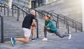 Full length shot of sportive middle aged couple, man and woman stretching legs while exercising together outdoors on a Royalty Free Stock Photo