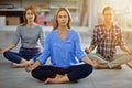 Refreshing their minds before work. Full length shot of three businesswomen meditating in the office. Royalty Free Stock Photo