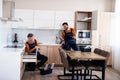 Full length shot of two handymen, workers in uniform talking while assembling kitchen cabinet using screwdriver indoors Royalty Free Stock Photo