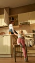 Full length shot of two naughty kids, brother and sister trying to find something sweet in the kitchen cupboard. Little