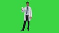 Mature doctor in whitecoat describing new pills in box on a Green Screen, Chroma Key.