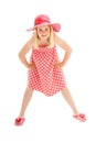 Full length shot of young blonde girl wearing pink floppy hat, a polka dot dress and flip flops. Isolated on white studio Royalty Free Stock Photo