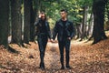 Full-length shot of young couple in love walking in the autumn park holding hands. Royalty Free Stock Photo