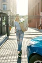 Full length shot of young woman going to unlock her car while holding grocery bag after shopping in the supermarket Royalty Free Stock Photo