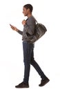 Portrait of happy african american man walking with mobile phone and bag Royalty Free Stock Photo