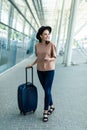 Portrait of a happy woman walking with suitcase at airport Royalty Free Stock Photo