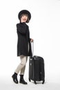 Full length side portrait of woman walking with travel bag and talking on mobile phone isolated on white background Royalty Free Stock Photo