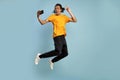 Full length side profile body size photo funky funny young African-American man jump high, show v-sign gesture, make