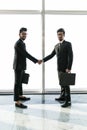 Full length side view of asian businessmen shaking hands in office building with panoramic glasses Royalty Free Stock Photo